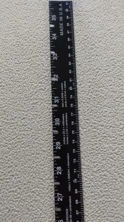 Aluminum ruler with fret locations marked.